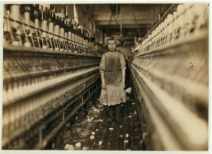 A young girl standing in a spinning factory