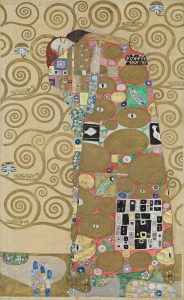 A detail from Gustav Klimt's frieze panels in the house, which depicts a woman with a highly patterned cloak or gown against a backdrop with a tree of life motif.