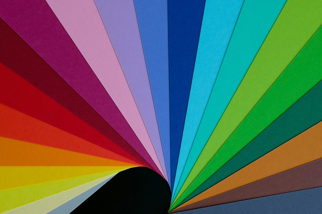 An abstract computer-generated image with rainbow-colored triangles spreading expansively across the space in diagonal lines.