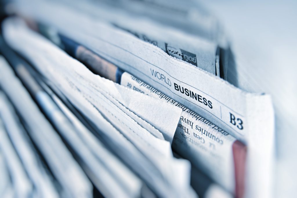 a close-up photograph of the top edges of a large stack of newspapers