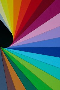 An abstract computer-generated image with rainbow-colored triangles spreading expansively across the space in diagonal lines.
