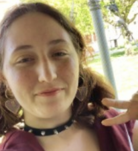 Ellie Craft holding a peace sign with her hand.