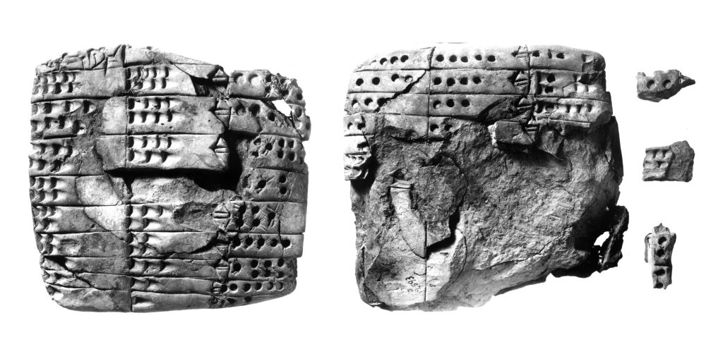 A greyscale image of the clay tablet VAT 12593 showing its obverse on the left and its reverse on the right. To the right of the reverse are three small fragments of the tablets face. The tablet is the shape of a square with rounded edges. It has some places where the face of the tablet has been broken off. Over half of the reverse side's face is missing. The front and back are organized into three columns and several rows containing numerals. These numerals are impressed into the clay in the form of circular or bullet-shaped indentations of varying sizes.